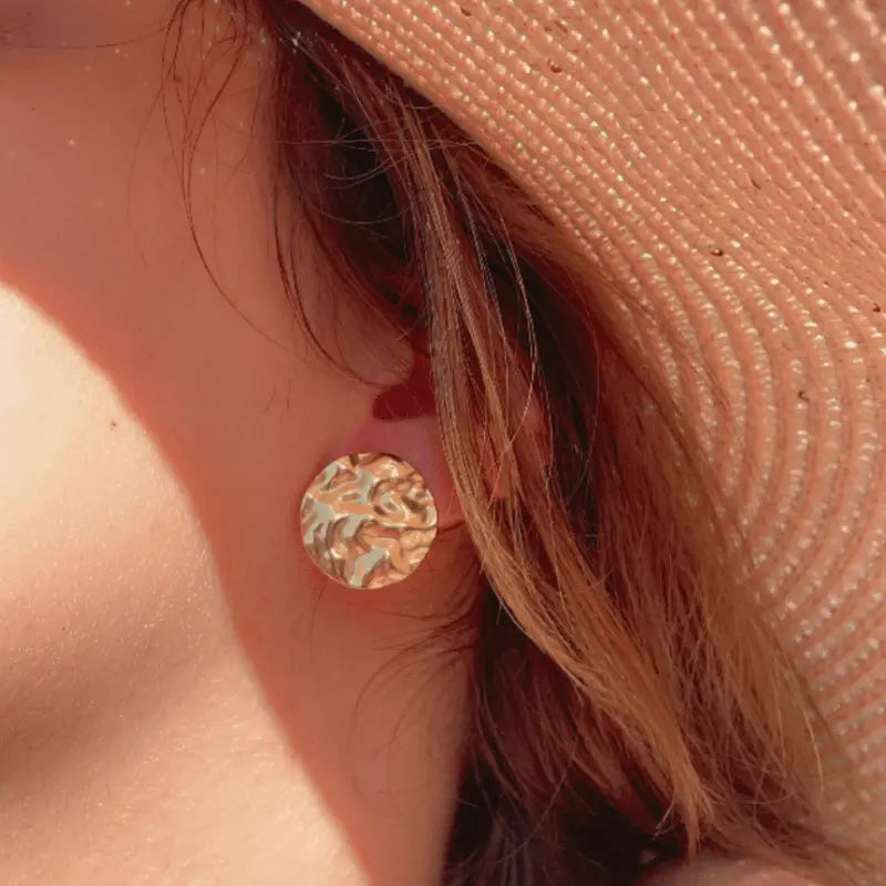 Boucles d'oreilles rondes en acier inoxydable avec une texture martelée, portées pour un look élégant