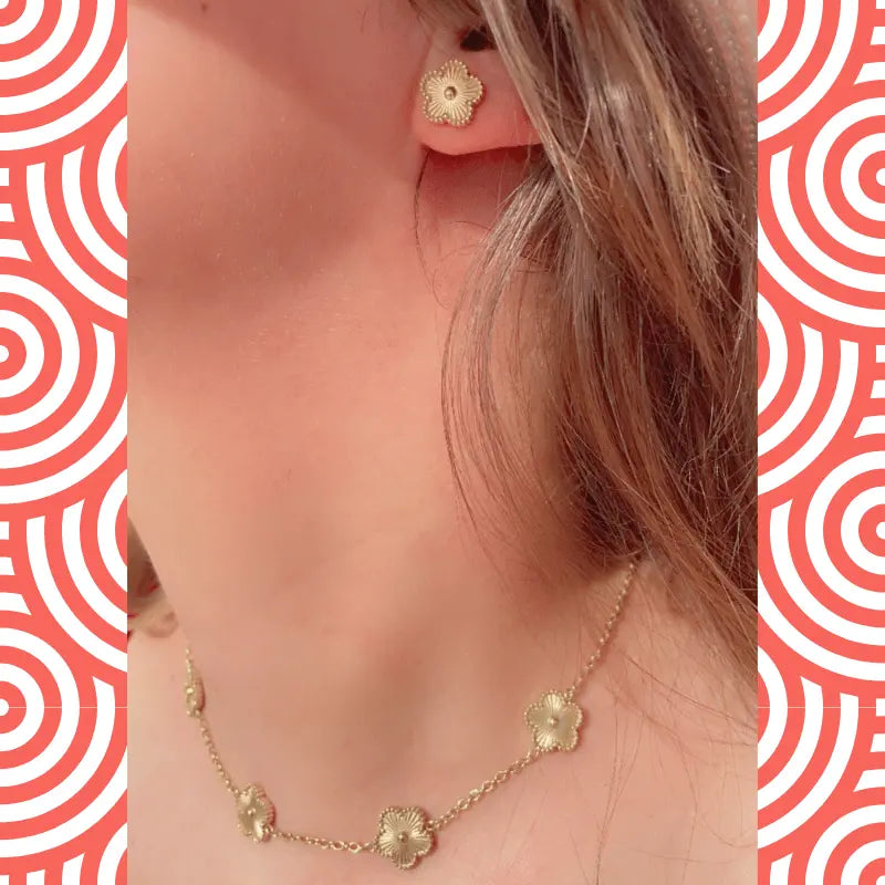 Boucles d'oreilles en acier inoxydable dorées en forme de fleur, portées avec un collier assorti