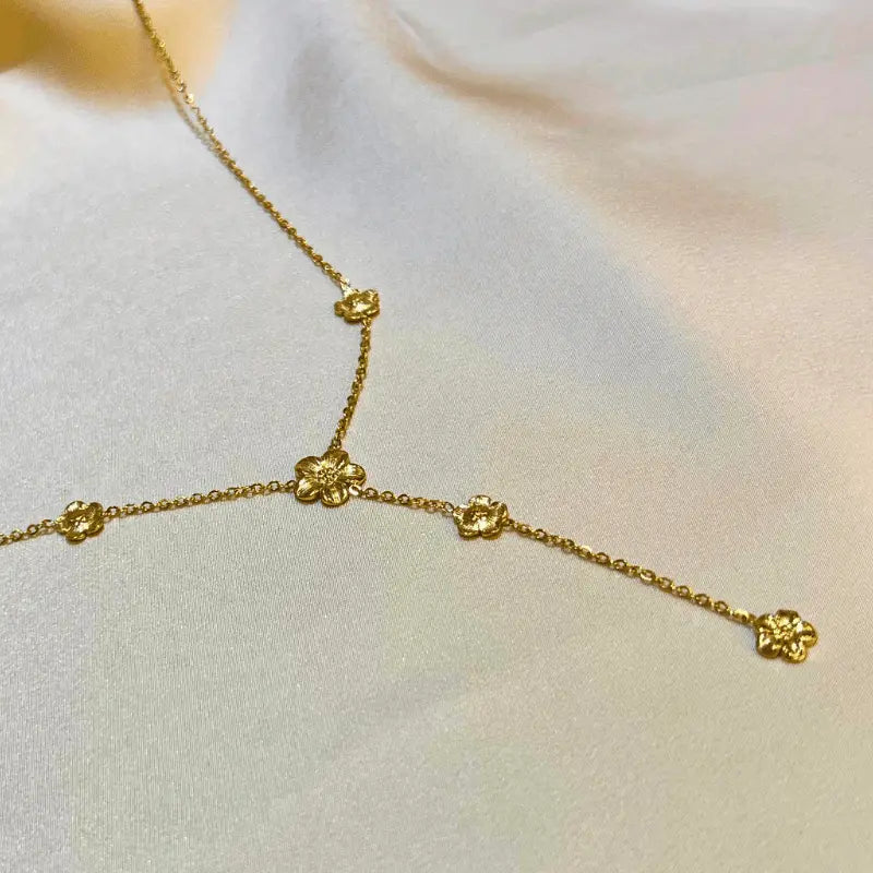 Détail du collier Y en acier inoxydable avec motifs de fleurs, pour un style délicat et élégant.