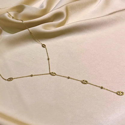Collier long en acier inoxydable en forme de Y sur fond beige élégant