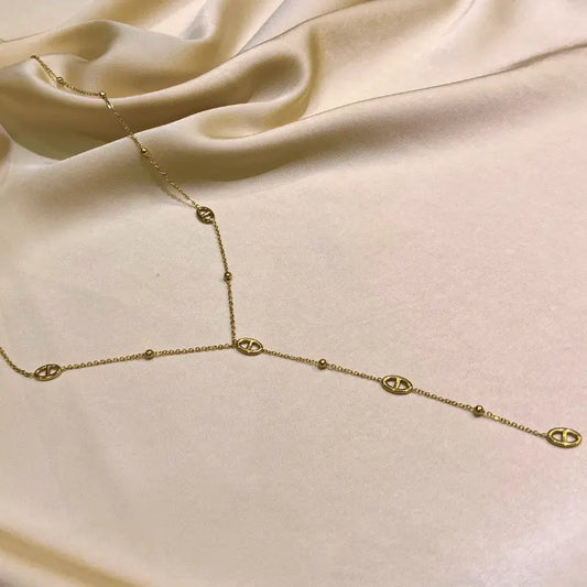 Collier long en acier inoxydable en forme de Y sur fond beige élégant