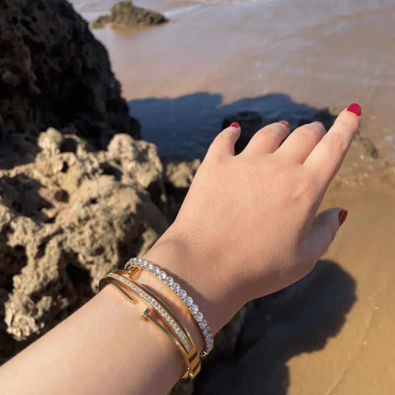 Superposition de bracelets en acier inoxydable avec strass, créant un look tendance et raffiné pour toutes les occasions.